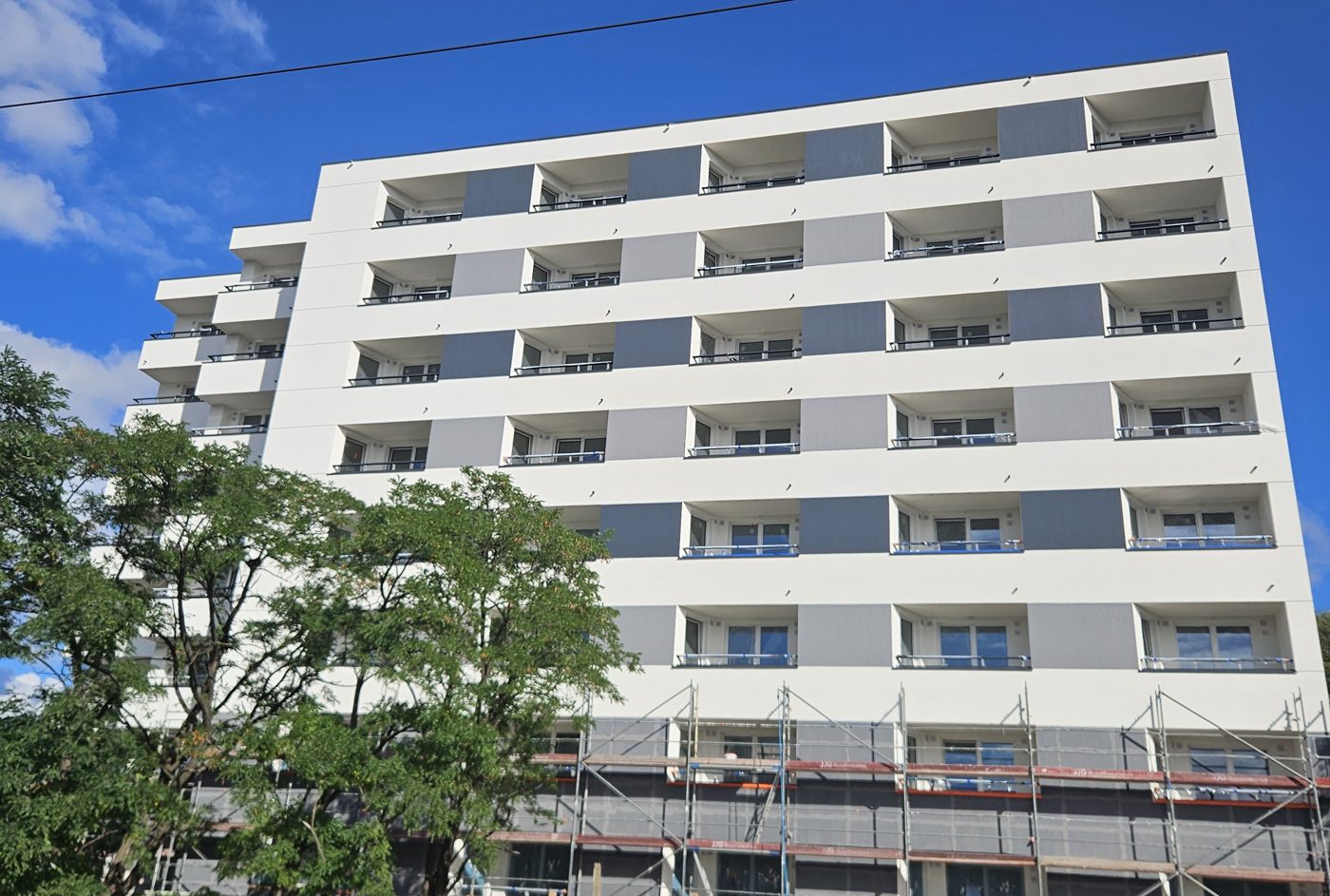 Elewacja frontowa budynku wielorodzinnego, Warszawa Białołęka, ul. Marywilska – docieplenie ETICS, tynk cienkowarstwowy, ryflowane wstawki w kolorach grafitowym i jasnoszarym